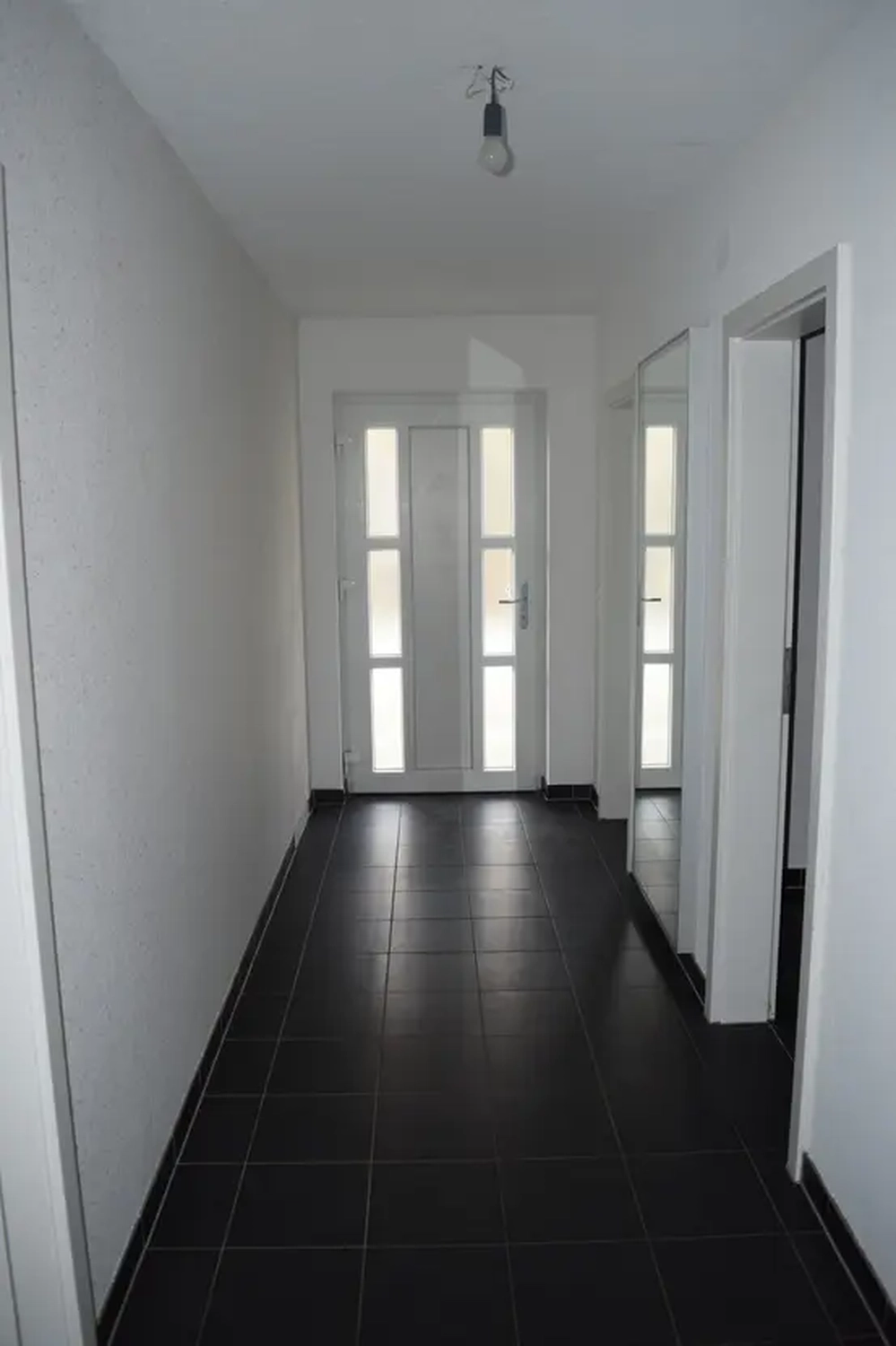 Michaela Hain Immobilien - Wohnung Wohnzimmer mit großer LED, Balkonblick